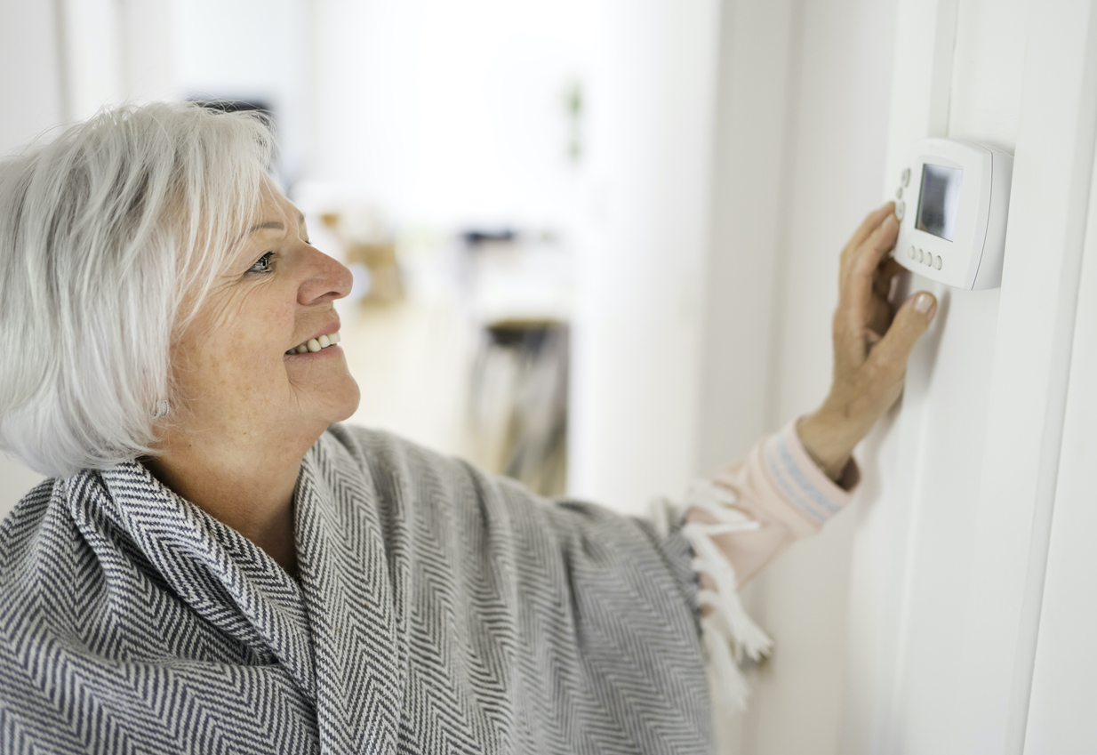 woman adjusting her thermostat